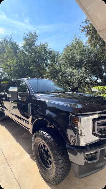Black Ford Super Duty after a full detail, parked on a driveway